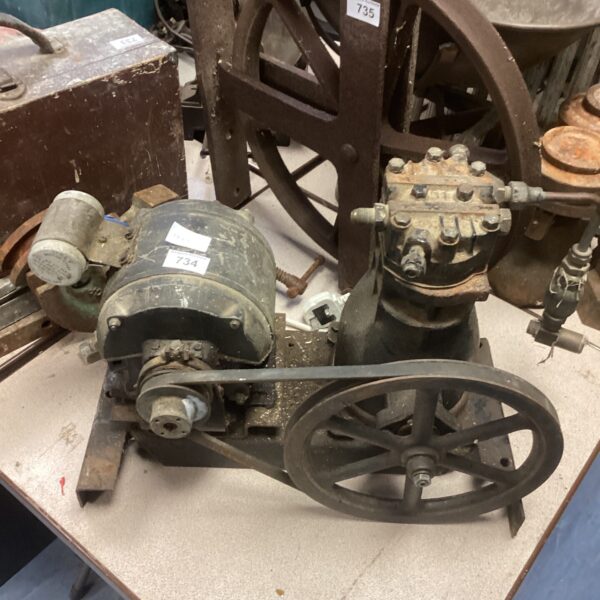 Vintage industrial pulley system with a large wheel and motor mount.