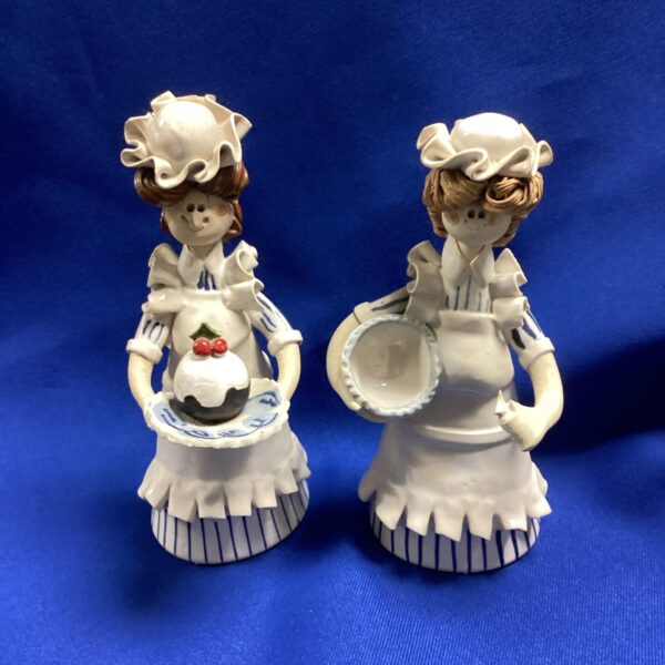 Vintage porcelain figurine holding a cherry-filled magazine rack.
