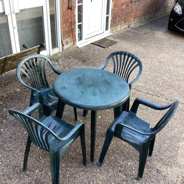 Vintage green garden bistro set with table and four chairs.