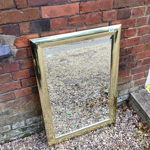 Vintage gilt framed mirror with ornate detailing.
