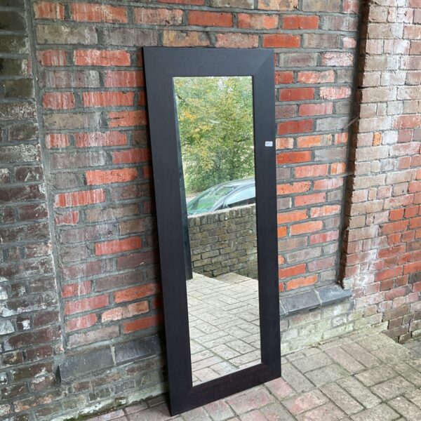 Antique black framed mirror with ornate detailing.