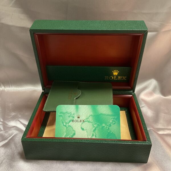 Vintage Rolex box with green leatherette exterior and velvet interior.