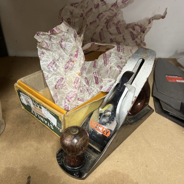 Vintage Stanley hand plane with wooden handle and metal body.
