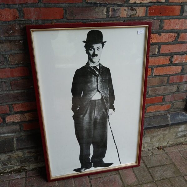 Framed vintage Charlie Chaplin poster, iconic silent film star.