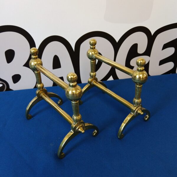 Vintage brass fire dogs for a classic fireplace hearth.
