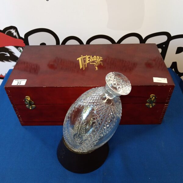 Clear crystal rugby ball shaped decanter for spirits.