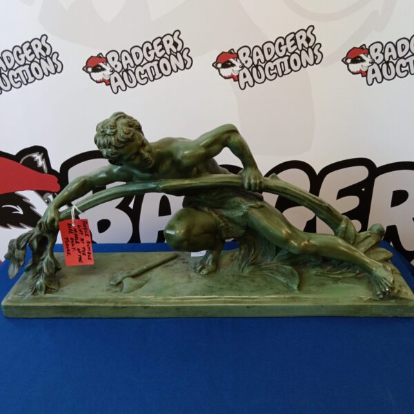 Antique bronze sculpture of a strongman bending a tree.