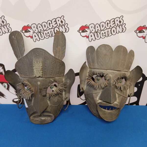 Vintage Mexican folk art masks crafted from tin.