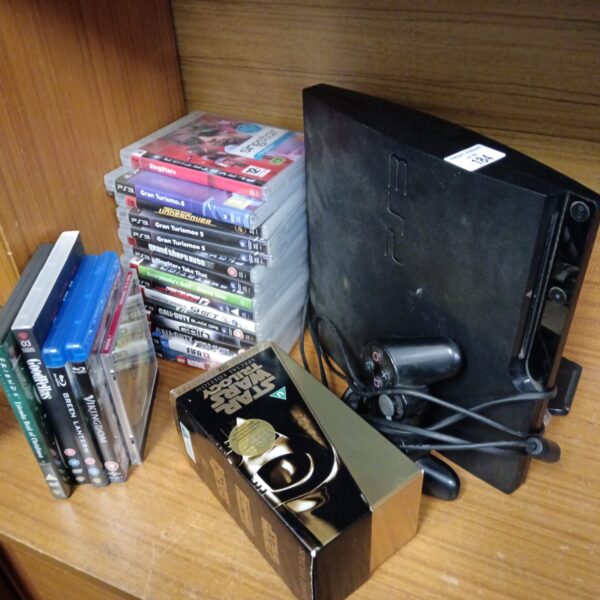 Black Sony Playstation 3 console with game discs.