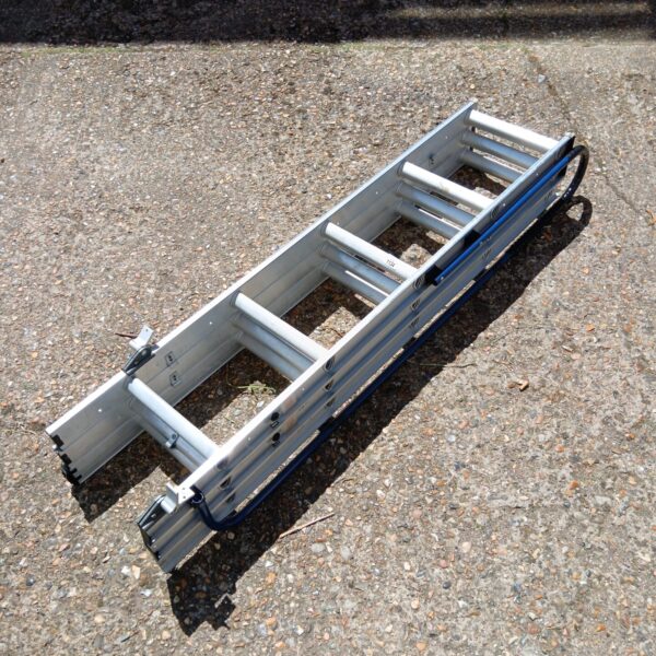 Silver aluminium loft ladder folded and leaning against a wall.