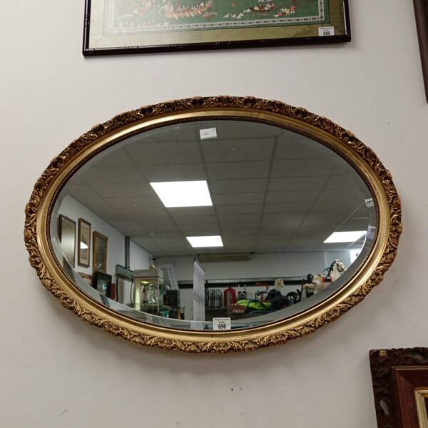 Antique gilt framed oval mirror with bevelled edge.