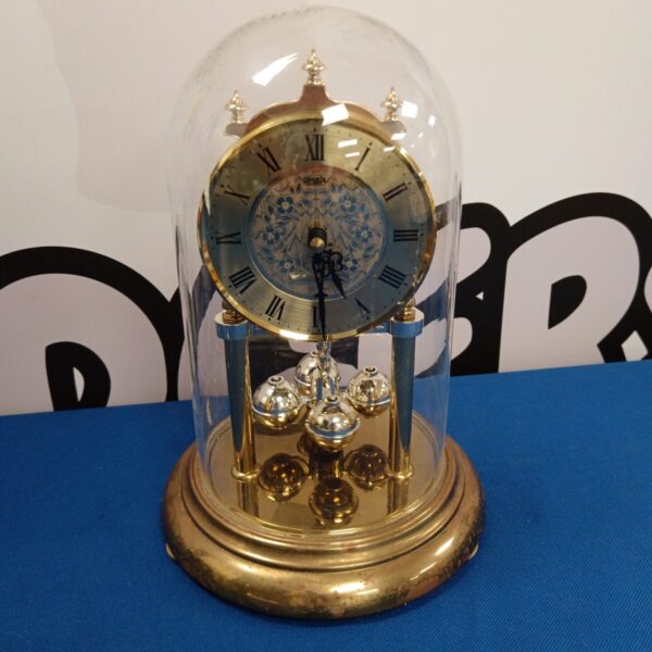 Elegant Hermle quartz clock under a glass dome.