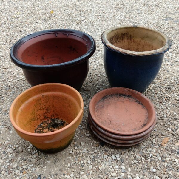 Group of three large terracotta plant pots for garden use.