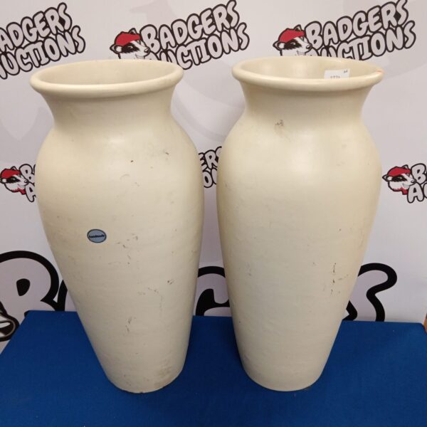 Pair of large handmade pottery vases on a neutral background.