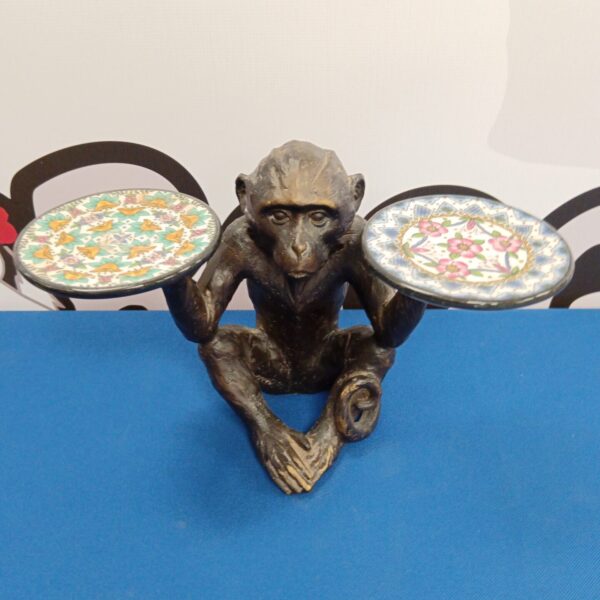 Detailed bronze monkey sculpture holding tea lights for home decor.