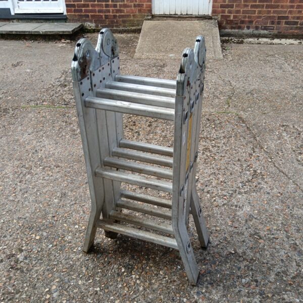 Side view of a used folding aluminium ladder.