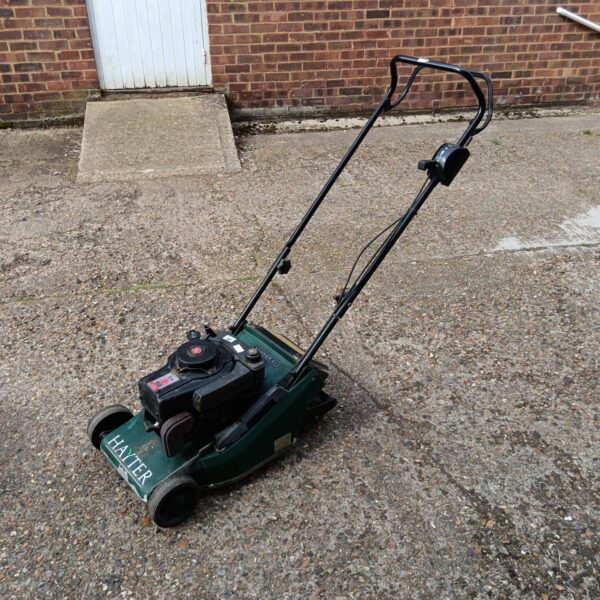 Vintage Hayter Harrier 41 petrol mower in a garden setting.