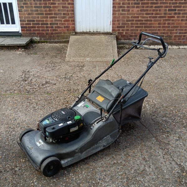 Hayter Harrier 56 Pro petrol lawn mower in a garden setting.