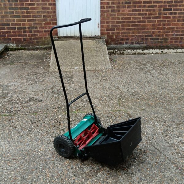 Vintage Bosch AHM 38 G push lawnmower in a garden setting.