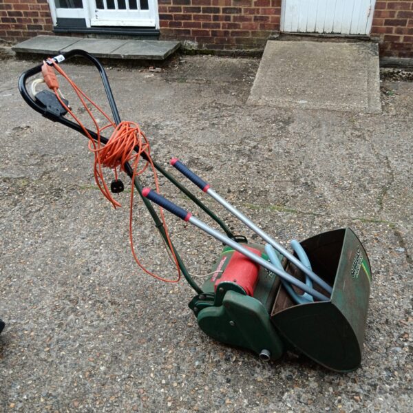 Vintage Qualcast EP30 electric lawnmower in a garden setting.