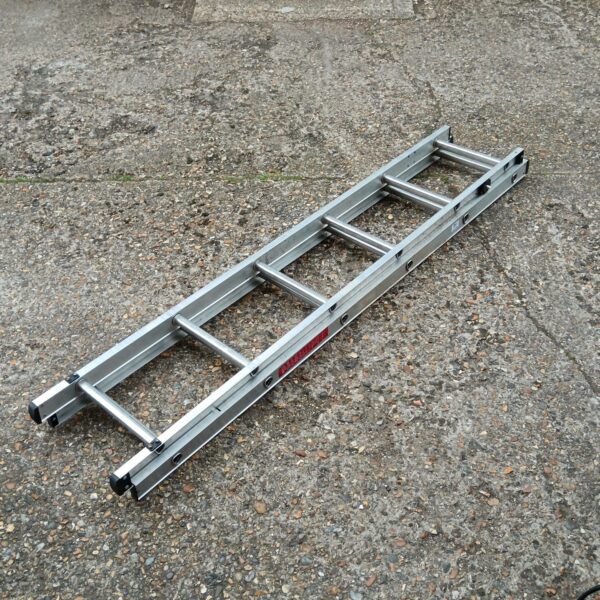 Silver extending aluminium ladder leaning against a wall.