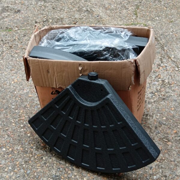 Four new black parasol weights still in their original packaging.