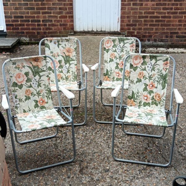 Set of four vintage floral folding chairs on a patio.