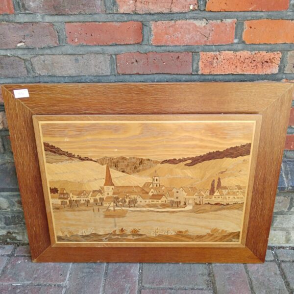 Vintage marquetry panel depicting a detailed riverside town scene.