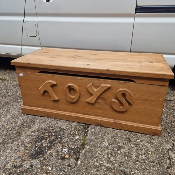 Vintage wooden toy chest with carved "TOYS" lettering.