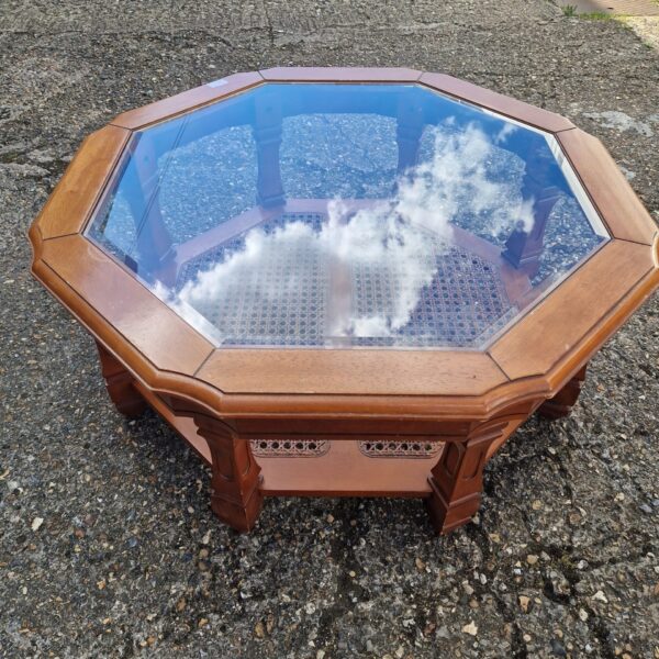 Vintage octagonal coffee table with glass top and wood frame.