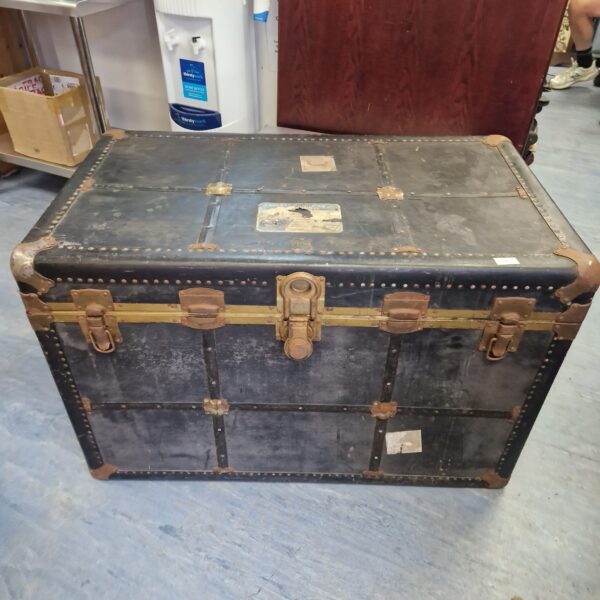 Large vintage travel trunk with canvas covering and metal accents.