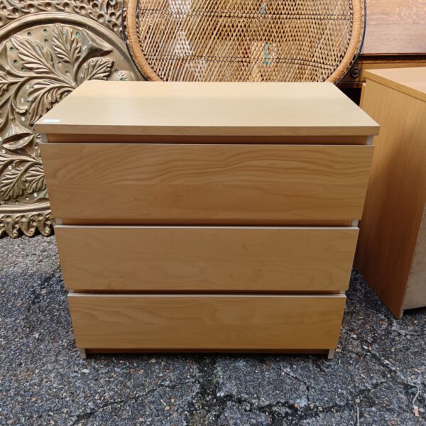 Pine effect three drawer cabinet for bedroom storage.