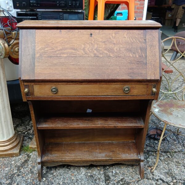 Vintage oak writing bureau with drawers and a sloping writing surface.