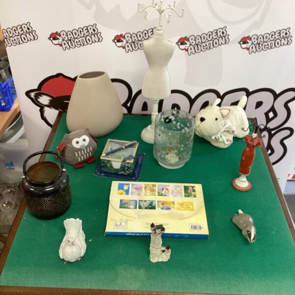 Overview of a mixed collectibles lot with figurines and a doorstop.