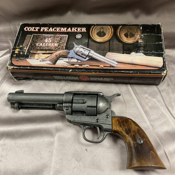 Detailed view of a Colt Peacemaker replica pistol with a blued finish.