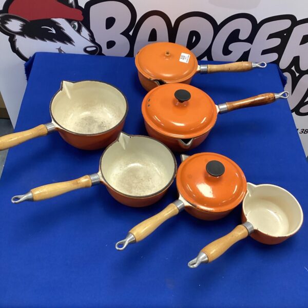 Six vintage iron cooking pans with wooden handles.
