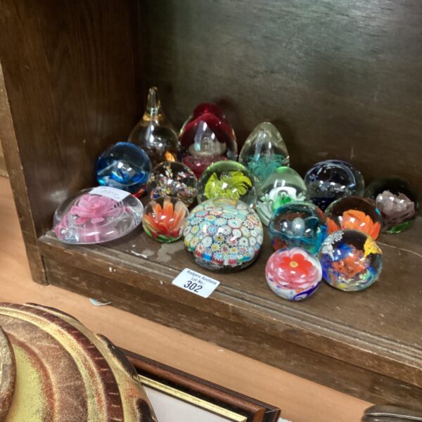 Quantity of colourful Murano glass paperweights on display.