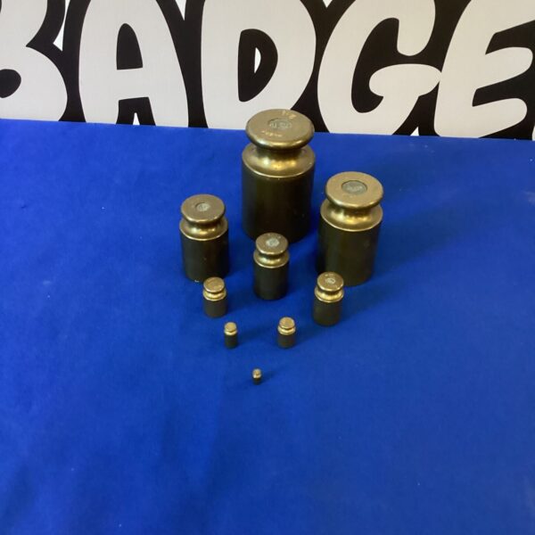 Set of nine vintage brass weights for scales and measuring.