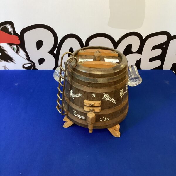 Rustic wooden barrel display with two tankards for home bar decor.