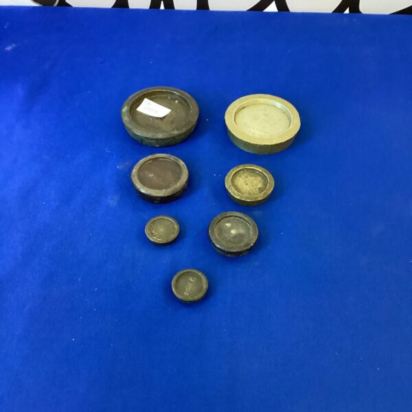 Vintage brass weight set on a dark surface.