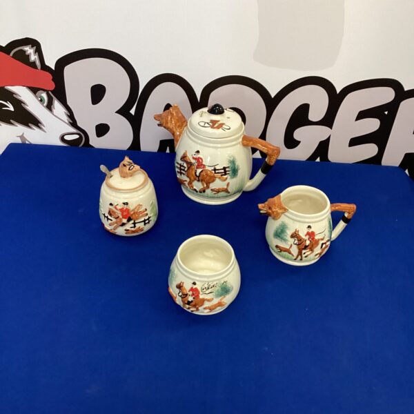 Vintage porcelain tea set with hunting scene details.