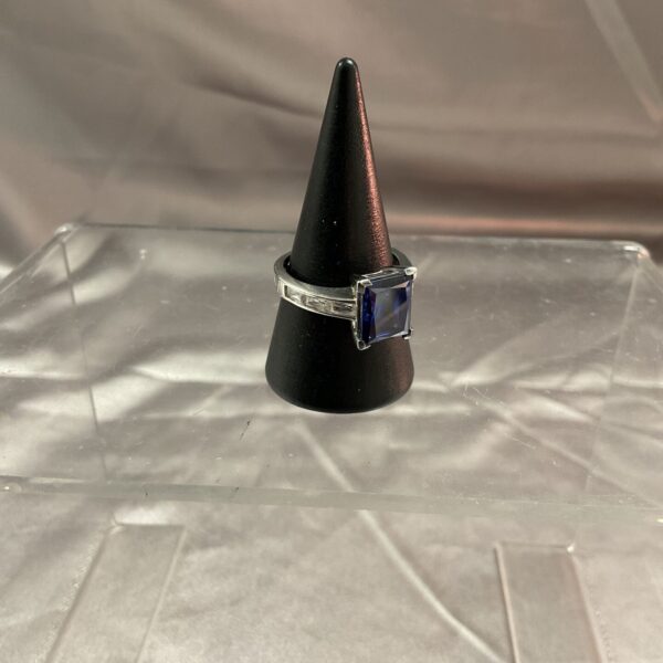 Silver ring with large blue and white stone setting.