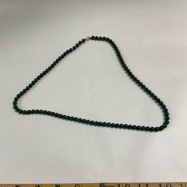 Vibrant green malachite bead necklace with a gold clasp.