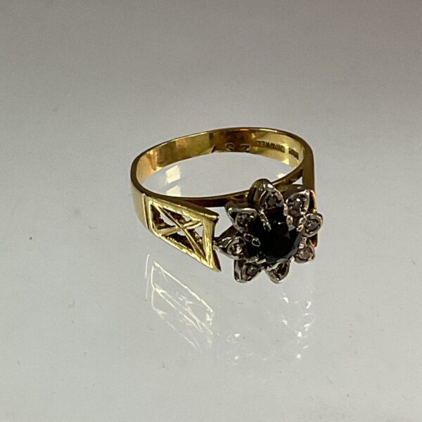 Close-up of vintage gold ring with sapphire and diamonds.