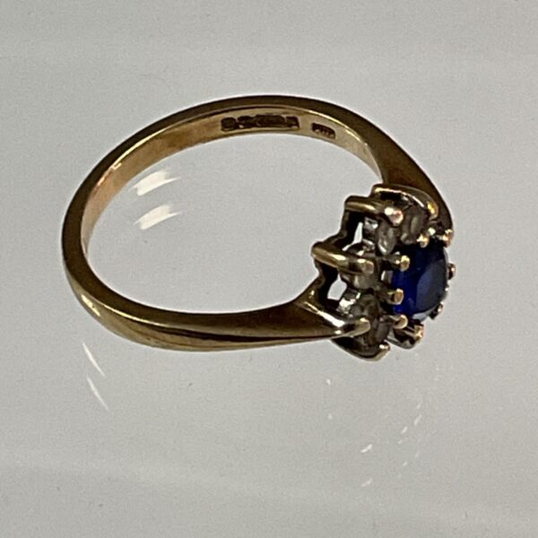 Close-up of a 9ct gold sapphire ring with white stones.