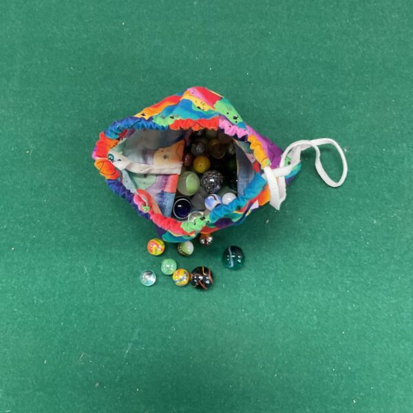 Colourful drawstring bag filled with a lot of vintage glass marbles.