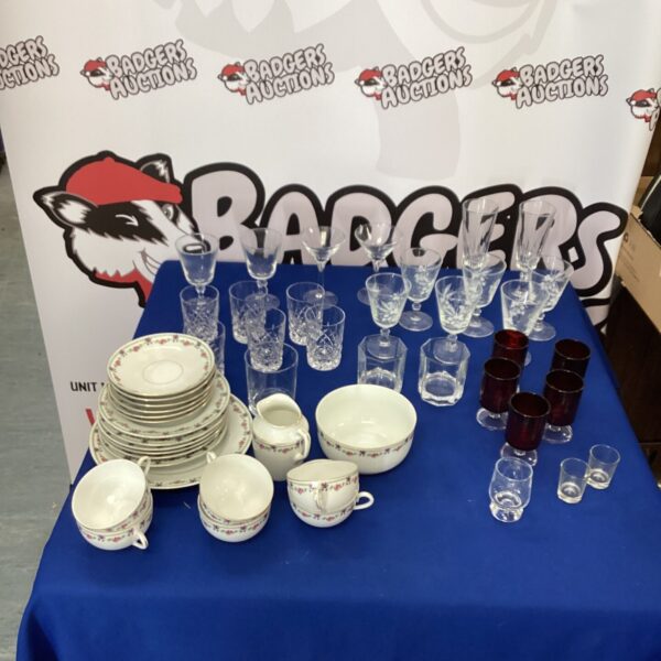 Vintage china tea set and mixed glassware collection on display.