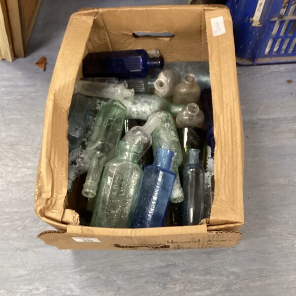 Antique bottle collection in a cardboard box, vintage glass.
