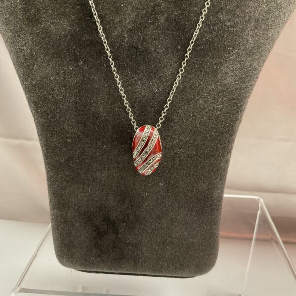 Close-up of silver marcasite and enamel pendant necklace.