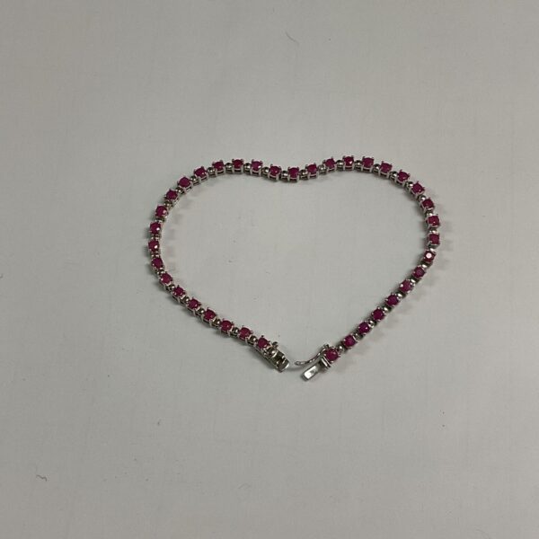 Close-up of a silver bracelet with vibrant red rubies.